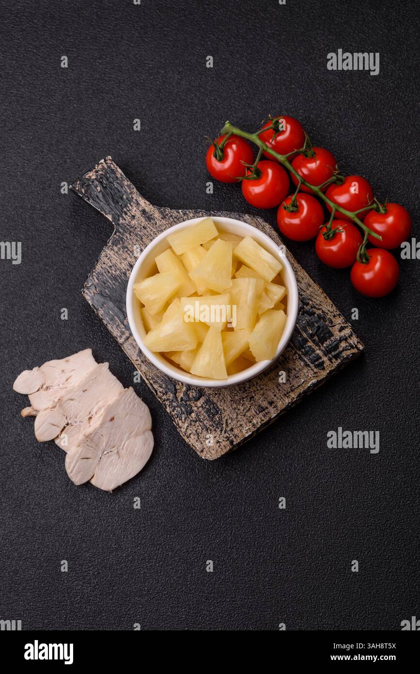 Frutta tropicale dolce in scatola di ananas tagliata a fette. Ananas come ingrediente per pizza o insalata Foto Stock
