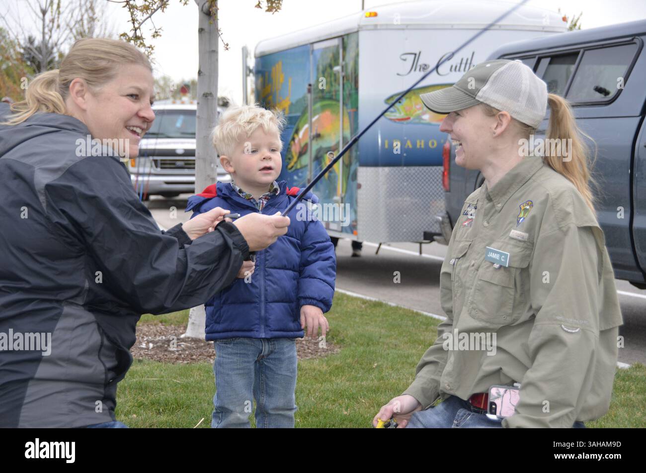 10 aprile 2015 - ID, Stati Uniti - da sinistra Shelley Henrikson di Boise aiuta suo figlio, Andew Thomas, 3 anni, a usare una canna da pesca mentre Jamie Carpenter con Idaho Fish and Game fornisce indicazioni. (Immagine di credito: © Roger Phillips/TNS/ZUMA Wire) Foto Stock