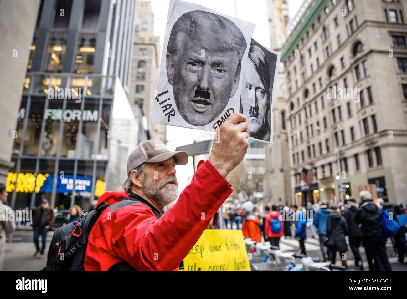 5 aprile 2025, New York City, New York, Stati Uniti: Un manifestante tiene dei manifesti che paragonano Donald Trump ad Adolf Hitler durante il distacco delle mani! dimostrazione. La protesta faceva parte del movimento nazionale "Hands Off!", che organizzò più di 1.000 manifestazioni nelle principali città degli Stati Uniti, tra cui Chicago, Boston e Washington. I manifestanti si sono riuniti per opporsi ai recenti tagli e alle politiche del governo guidati dal presidente Donald Trump e dal miliardario Elon Musk. (Credit Image: © Katie G. Nelson/SOPA Images via ZUMA Press Wire) SOLO PER USO EDITORIALE! Non per USO commerciale! Foto Stock