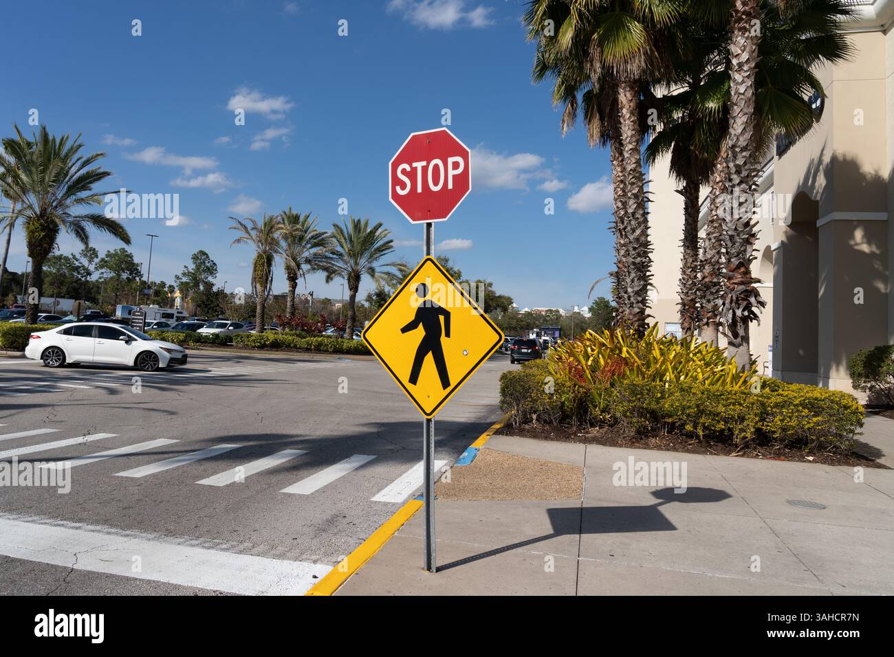 Un segnale di stop con un cartello di passaggio pedonale all'esterno di un centro commerciale è mostrato a Orlando, Florida, Stati Uniti. Foto Stock