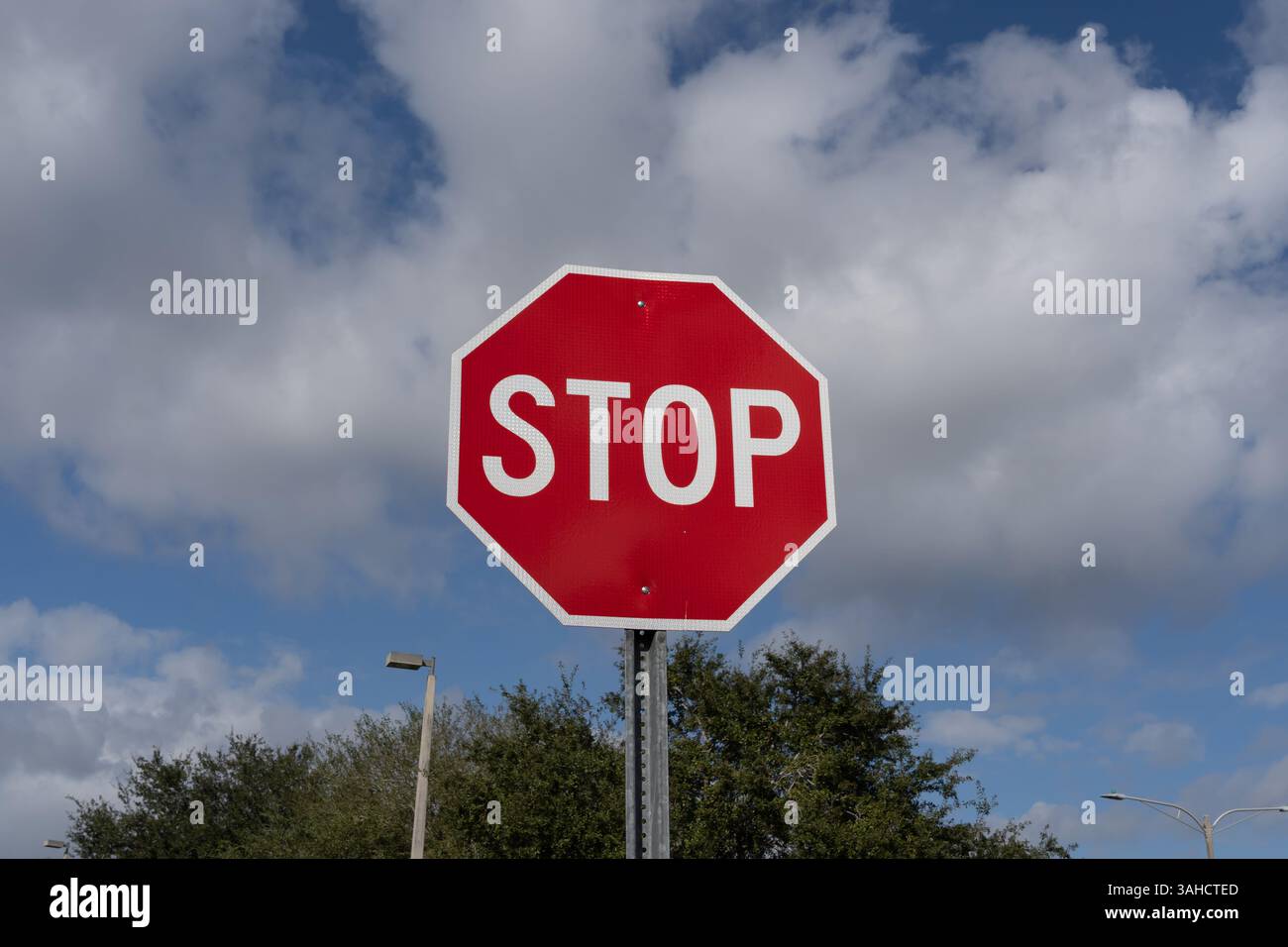 Segnale di stop con cielo blu e nuvole bianche sullo sfondo. Foto Stock