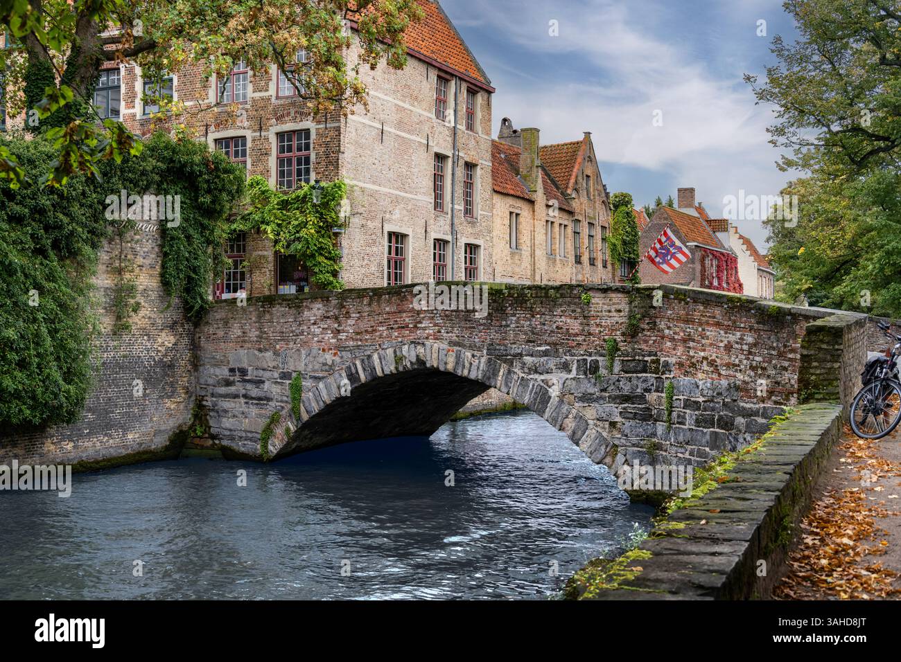 BRUGES, BELGIO - 09-27-2024: Veduta delle case cittadine e del ponte sul canale fluviale a Bruges, Belgio Foto Stock
