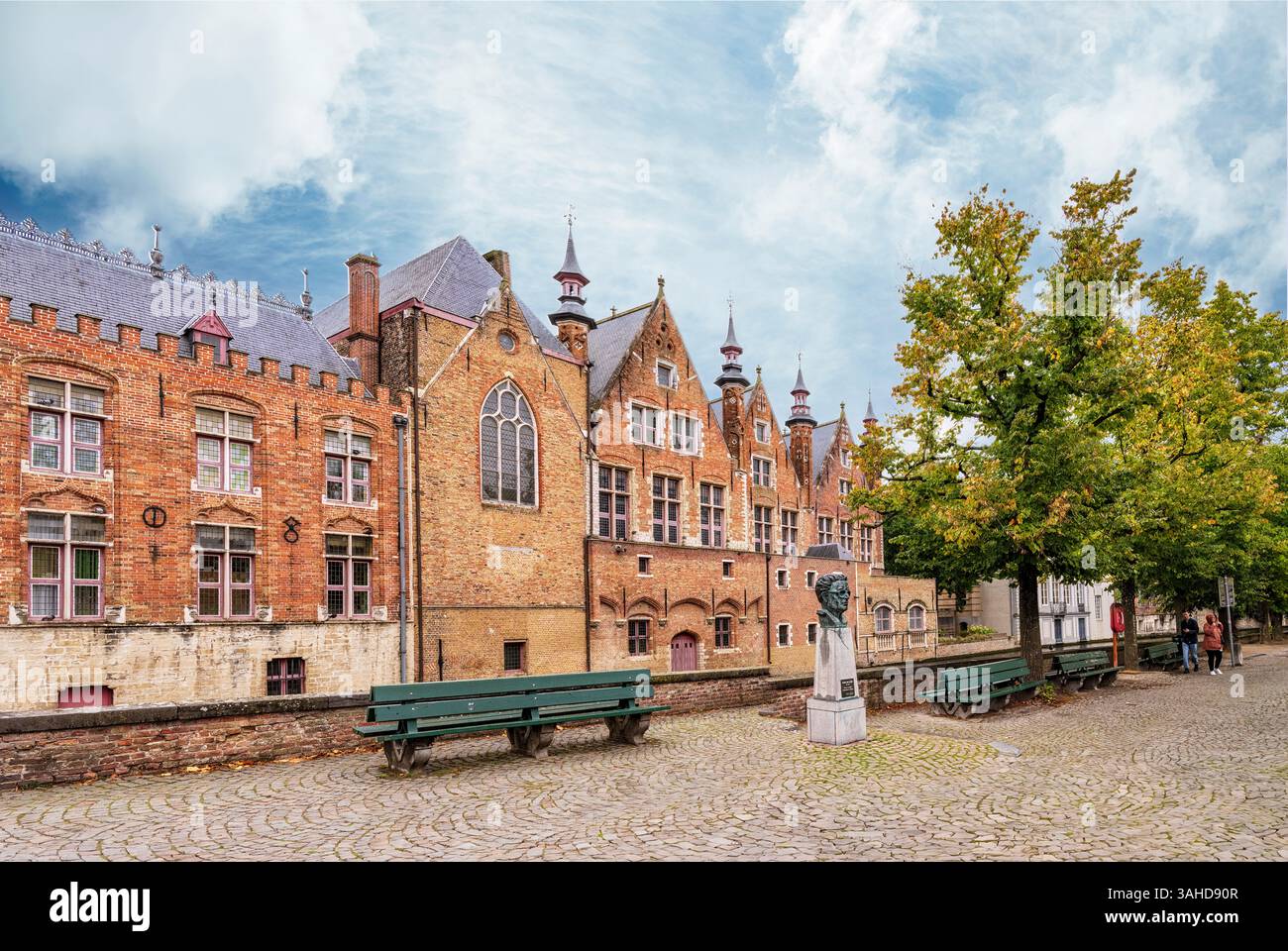 Bruges, Belgio - 09-27-2024:: Case medievali sul canale a Bruges (Bruges), Belgio. Statua di Frank Van Acker Foto Stock