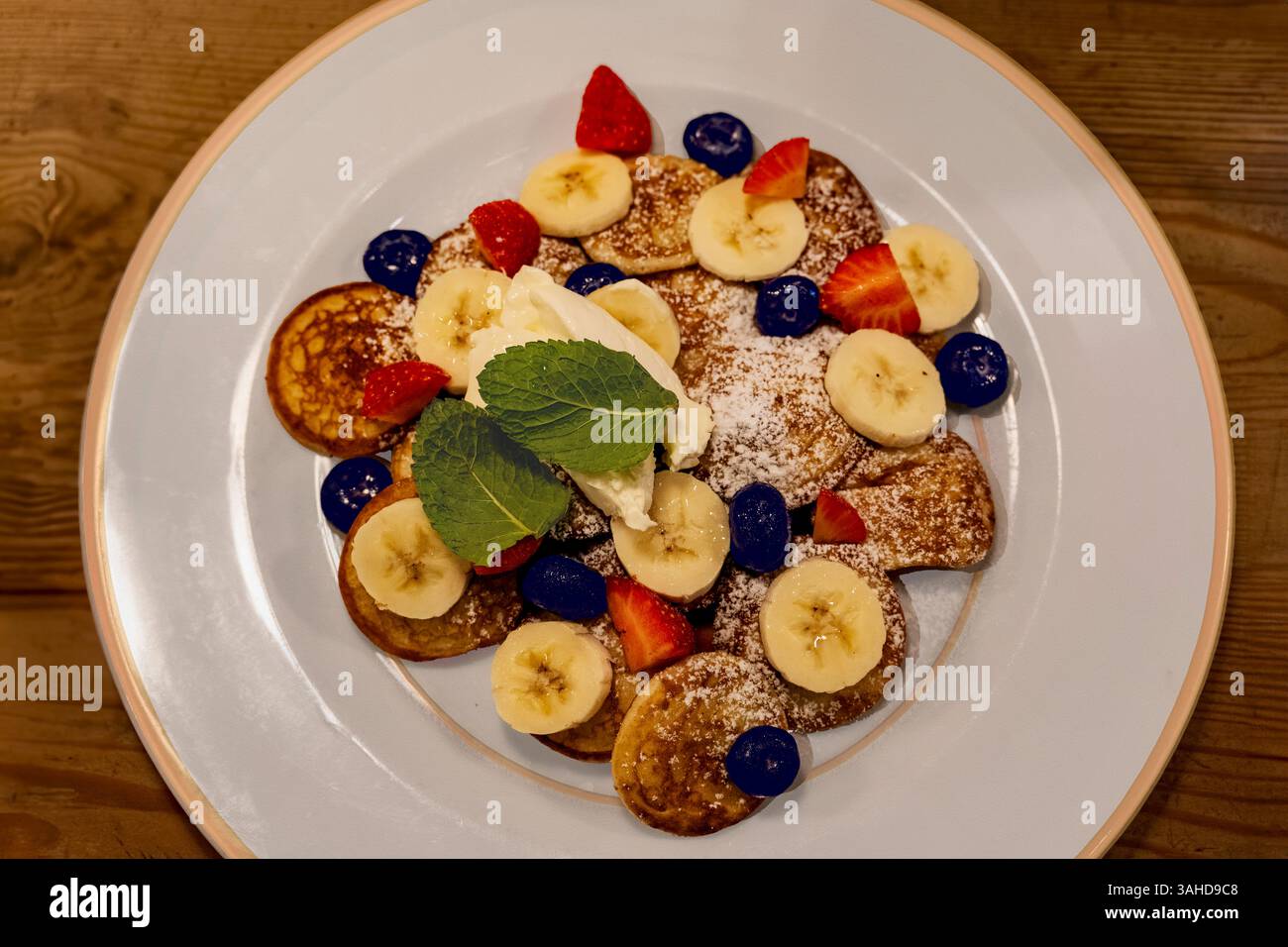Mini pancake belgi con mirtilli, fragole e banane. Foto Stock