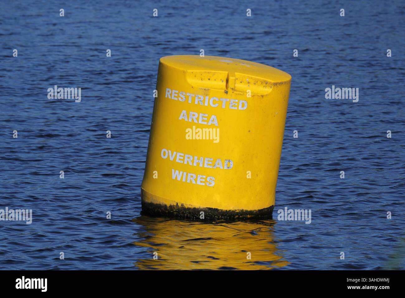 Boa gialla galleggiante sull'acqua con testo scritto su di essa per indicare un'area limitata a causa dei cavi sospesi Foto Stock