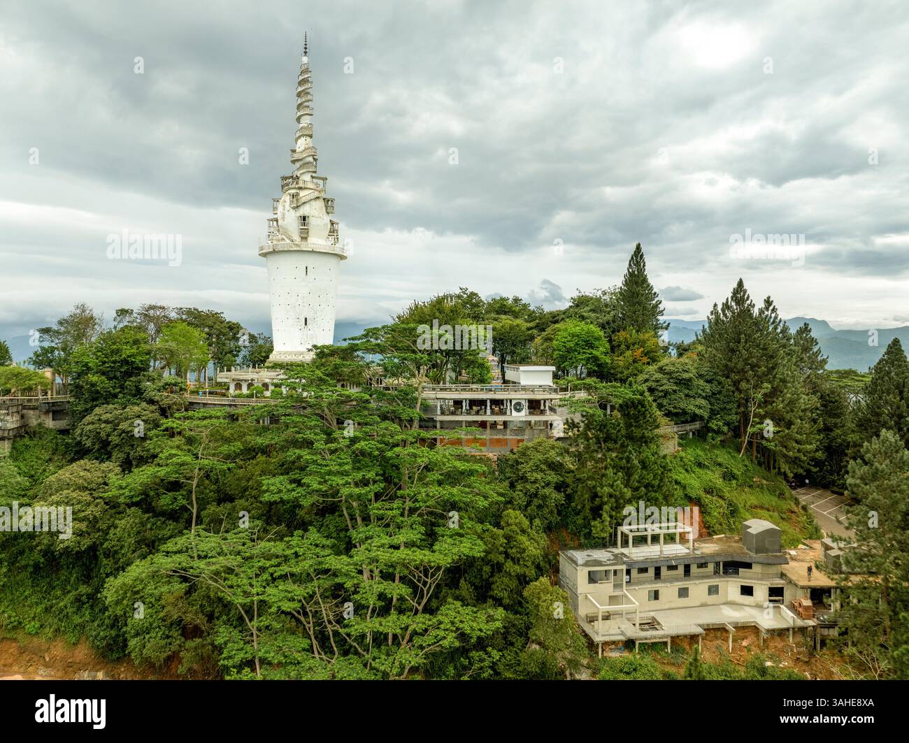 L'Ambuluwawa Tower a Gampola, Sri Lanka, si erge in cima a una lussureggiante montagna, offrendo vedute panoramiche e un design a spirale unico che simboleggia cultura e cultura Foto Stock