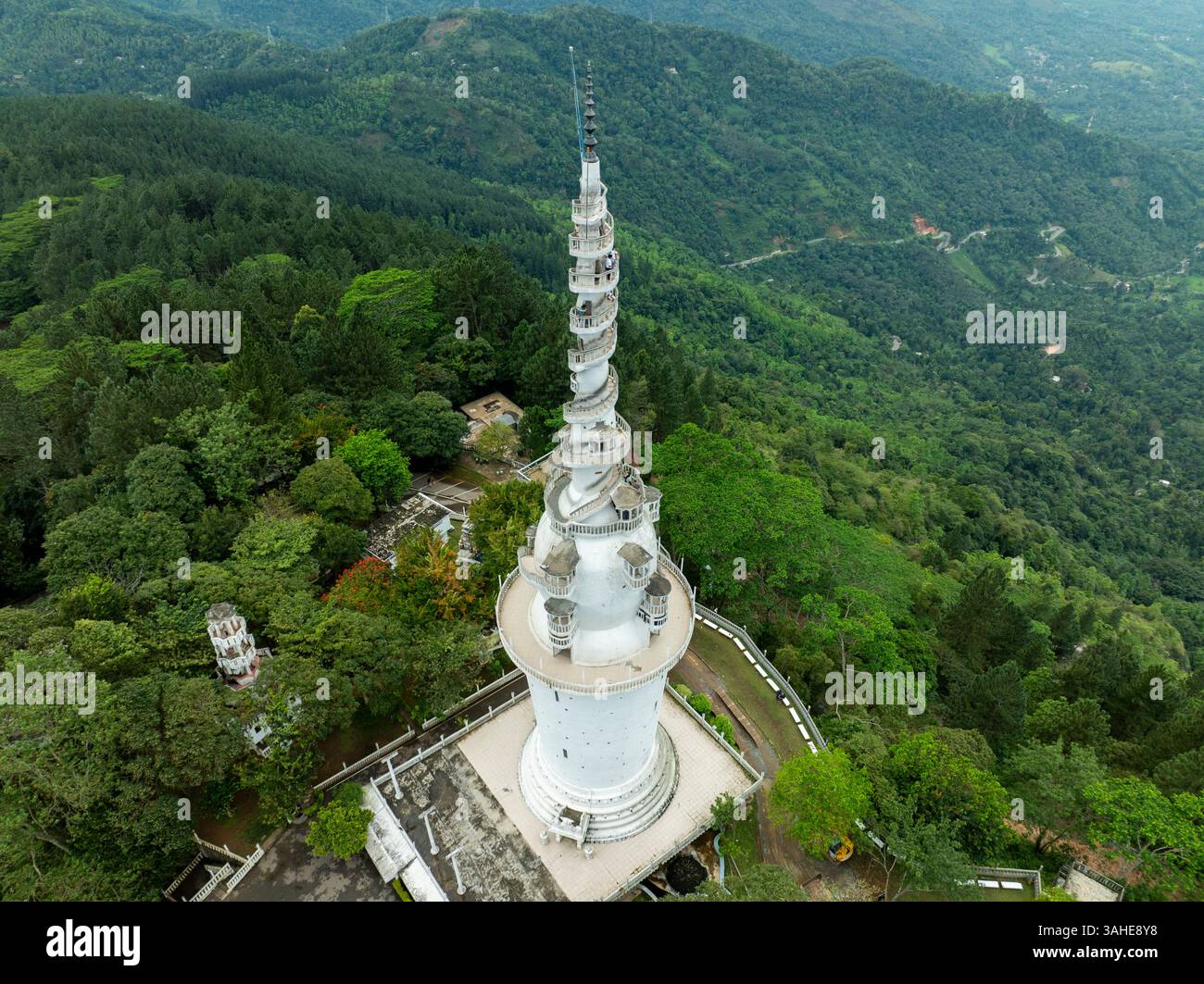L'Ambuluwawa Tower a Gampola, Sri Lanka, si erge in cima a una lussureggiante montagna, offrendo vedute panoramiche e un design a spirale unico che simboleggia cultura e cultura Foto Stock