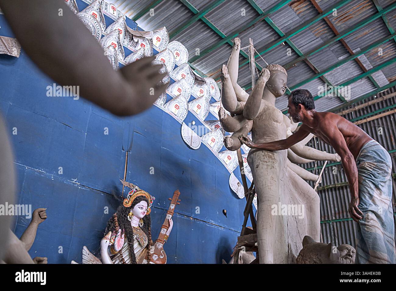 L'artista crea un idolo di argilla della dea Durga all'interno di un laboratorio davanti a Durga Puja, un importante festival indù celebrato in India e Bangladesh. Foto Stock