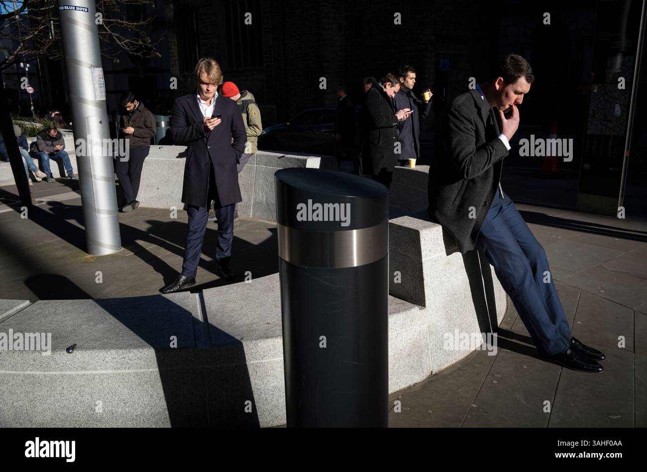 I lavoratori finanziari della città di Londra si siedono all'esterno in un giorno d'inverno fresco, riflettendo sull'attuale stagnante situazione economica all'inizio del 2025, in Inghilterra Foto Stock
