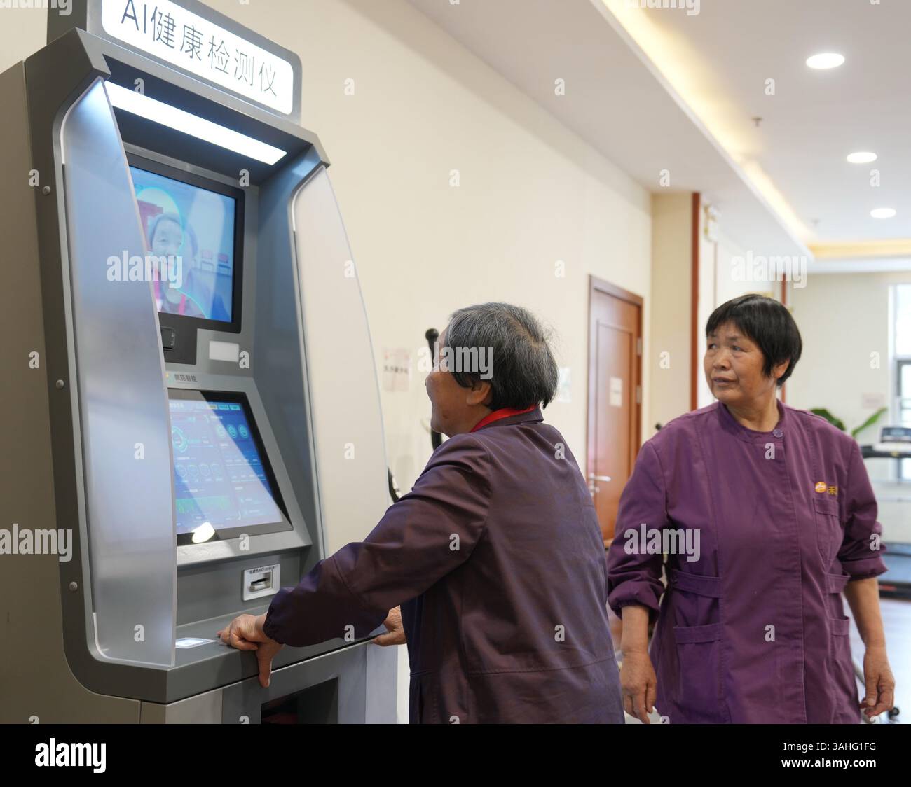 (250410) -- WUXI, 10 aprile 2025 (Xinhua) -- una donna anziana (L) prova un dispositivo di rilevamento della salute ai con l'assistenza di un membro del personale in una casa di cura nel distretto di Binghu di Wuxi, nella provincia di Jiangsu nella Cina orientale, 8 aprile 2025. Il rilevatore raccoglie e invia i dati sanitari alla stazione infermieri, consentendo un adattamento tempestivo dei piani infermieristici in base allo stato di salute degli anziani. Negli ultimi anni, la provincia di Jiangsu ha attivamente promosso lo sviluppo di alta qualità dell'Internet of Things, cercando di costruire un centro di innovazione industriale con influenza globale. A. Foto Stock
