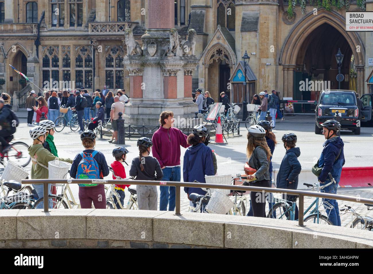 I turisti in un tour in bicicletta del centro di Londra con la loro guida. Le persone in gruppo ascoltando la guida del tour raccontano loro la storia. Foto Stock
