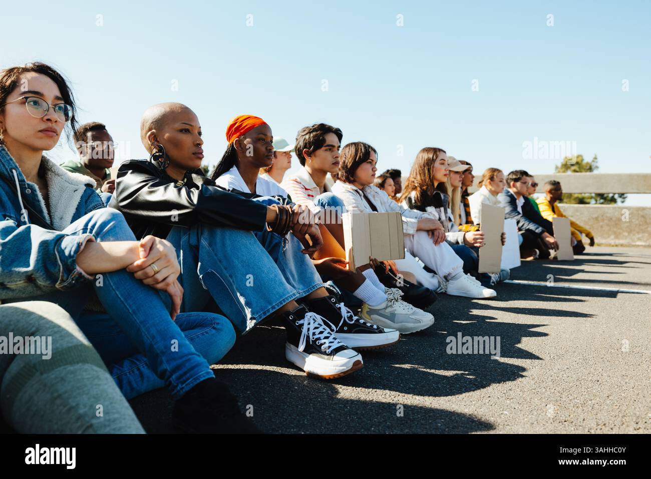 Un gruppo di lavoratori di varie età ed etnie, si riunirono in uno sciopero pacifico. Essi sono uniti mentre tengono dei segnali, dimostrando impegno. Foto Stock