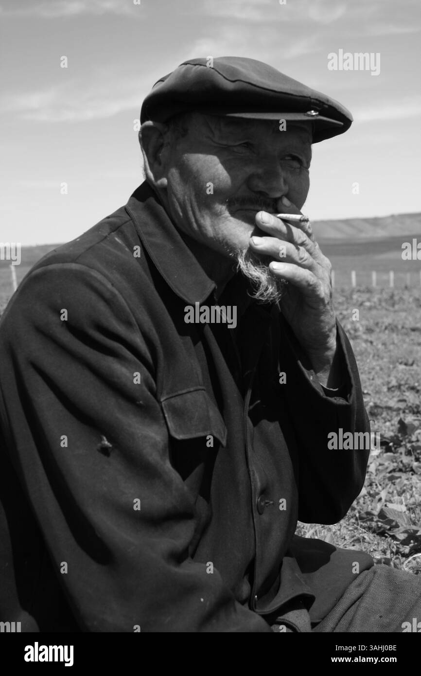 Ritratto autentico dell'anziano uomo kazako che fuma sulla prateria Tianshan dello Xinjiang - documentario sul patrimonio culturale e sulla vita rurale, Urumqi, Xinjiang, Cina, 2008. Foto Stock