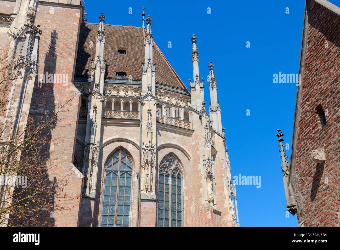 Immagine HDR della cattedrale di Ulm, la chiesa più alta del mondo, che mostra dettagli gotici sotto un cielo azzurro limpido in una giornata di sole. Perfetto per i viaggi, l'arco Foto Stock