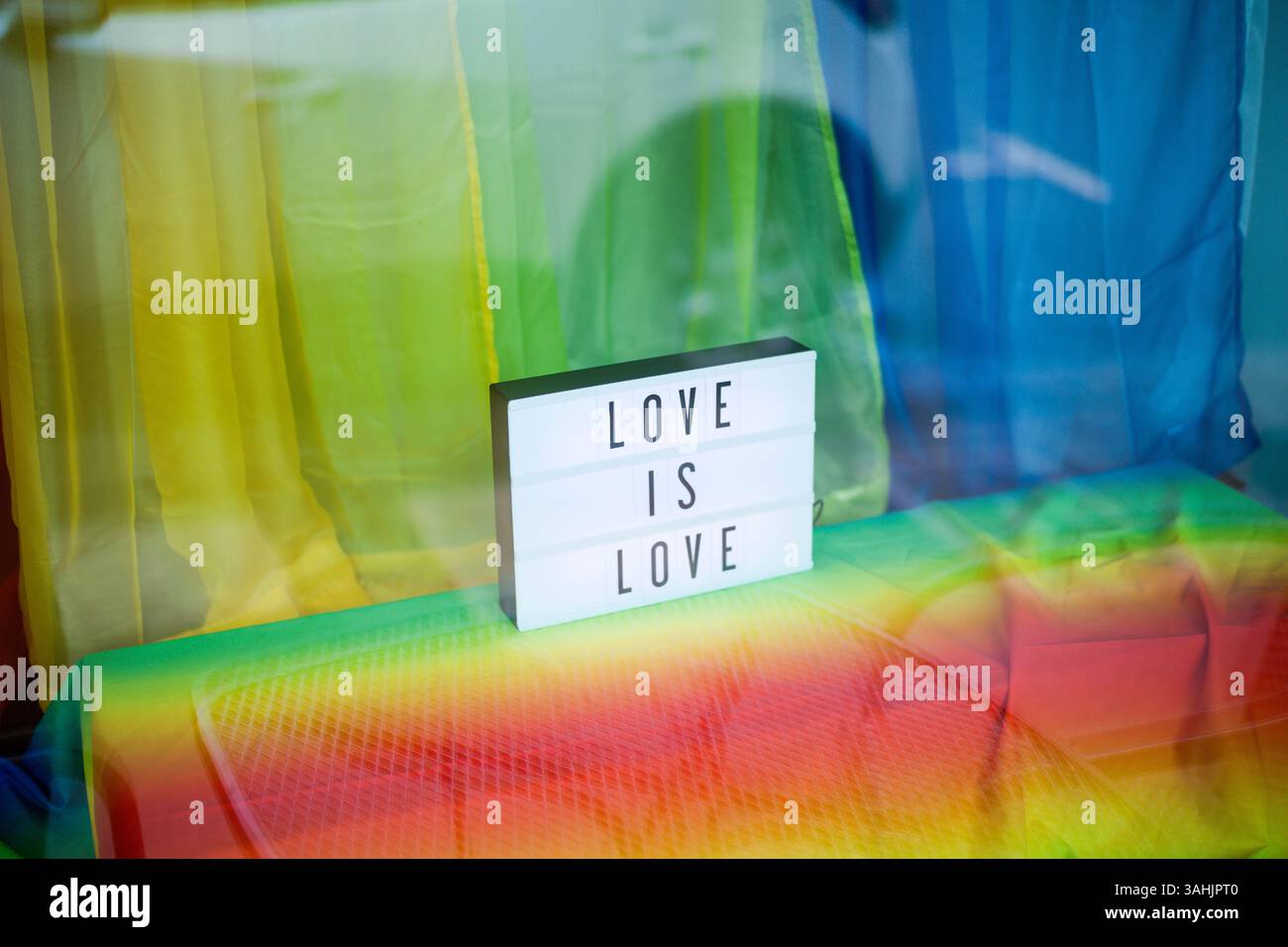 Insegna illuminata che mostra Love is Love su un vibrante sfondo arcobaleno. Oregon, Stati Uniti Foto Stock
