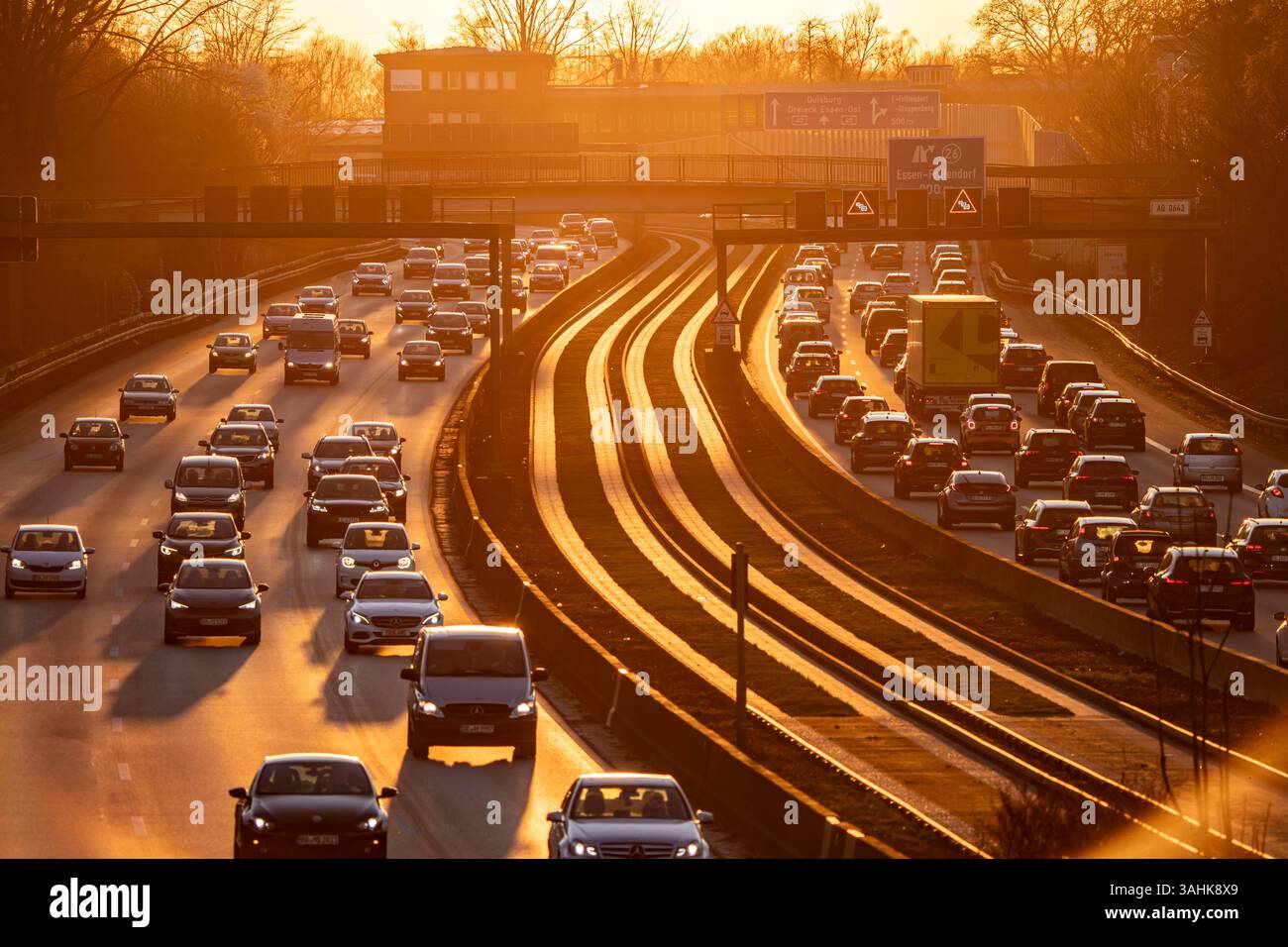 Autostrada A40, traffico intenso e lento, ora di punta serale allo svincolo di Essen-Kray, sole basso, linea di autobus nel mezzo dell'autostrada Foto Stock