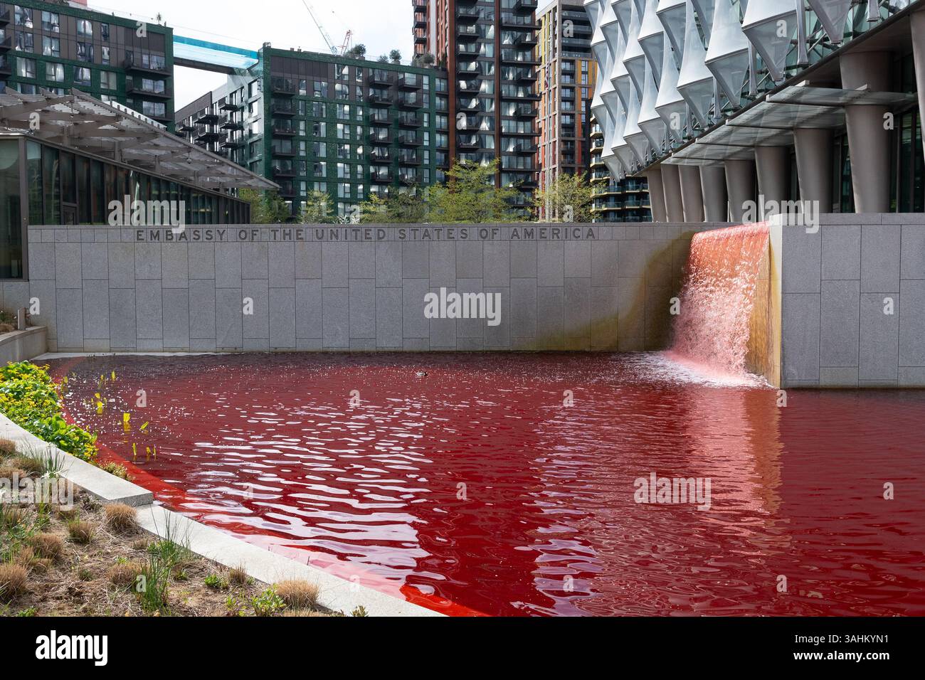 Londra, Regno Unito. 10 aprile 2025. Gli attivisti di Greenpeace tingono lo stagno che circonda l'ambasciata degli Stati Uniti a Nine Elms, Londra sangue rosso in una protesta contro il militarismo americano e il sostegno alla guerra di Israele a Gaza. Crediti: Ron Fassbender/Alamy Live News Foto Stock