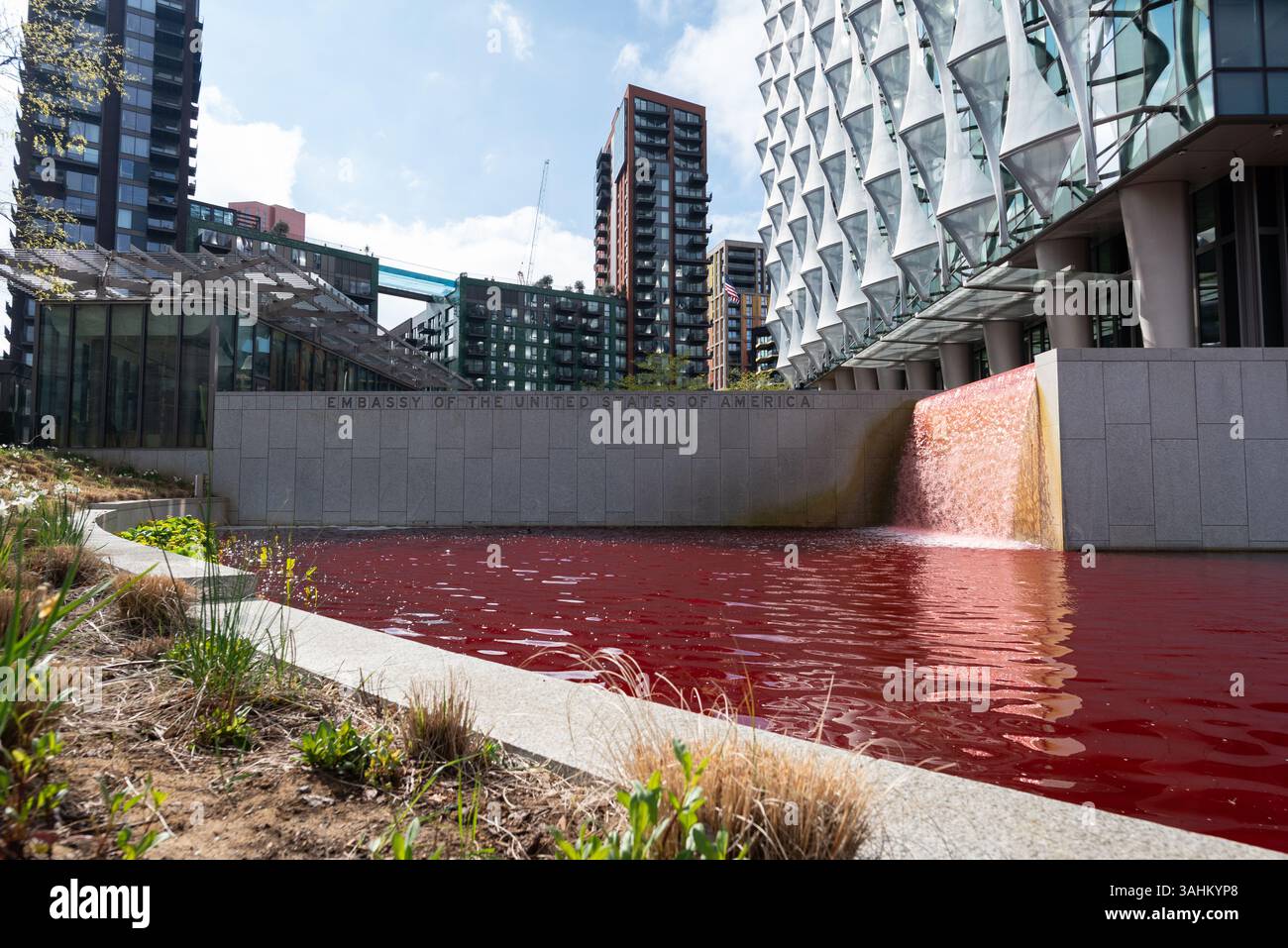 Londra, Regno Unito. 10 aprile 2025. Gli attivisti di Greenpeace tingono lo stagno che circonda l'ambasciata degli Stati Uniti a Nine Elms, Londra sangue rosso in una protesta contro il militarismo americano e il sostegno alla guerra di Israele a Gaza. Crediti: Ron Fassbender/Alamy Live News Foto Stock