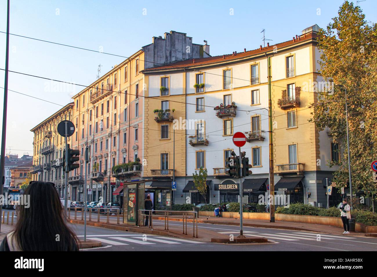 Milano, Italia - 12.01.2024: Luce nel tardo pomeriggio su via Milano con edifici classici e linee di tram. Foto Stock