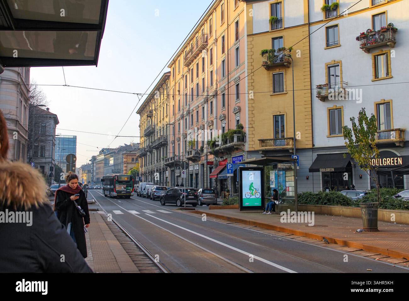 Milano, Italia - 12.01.2024: Luce nel tardo pomeriggio su via Milano con edifici classici e linee di tram. Foto Stock