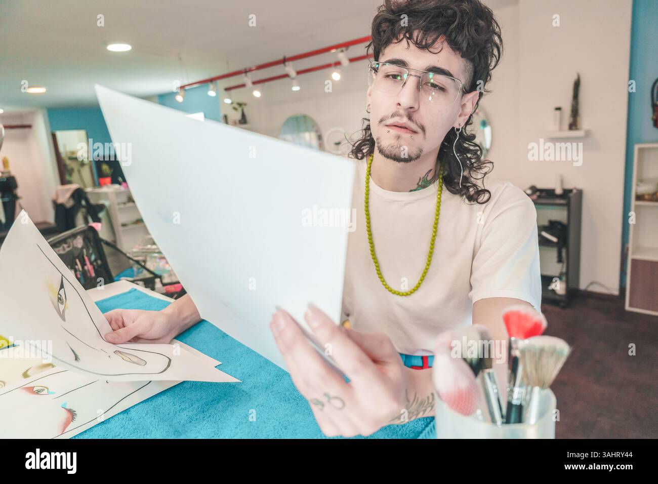 Il makeup artist esamina attentamente gli schizzi dettagliati del trucco in un elegante salone di bellezza, evidenziando il processo creativo e la meticolosa attenzione a ev Foto Stock