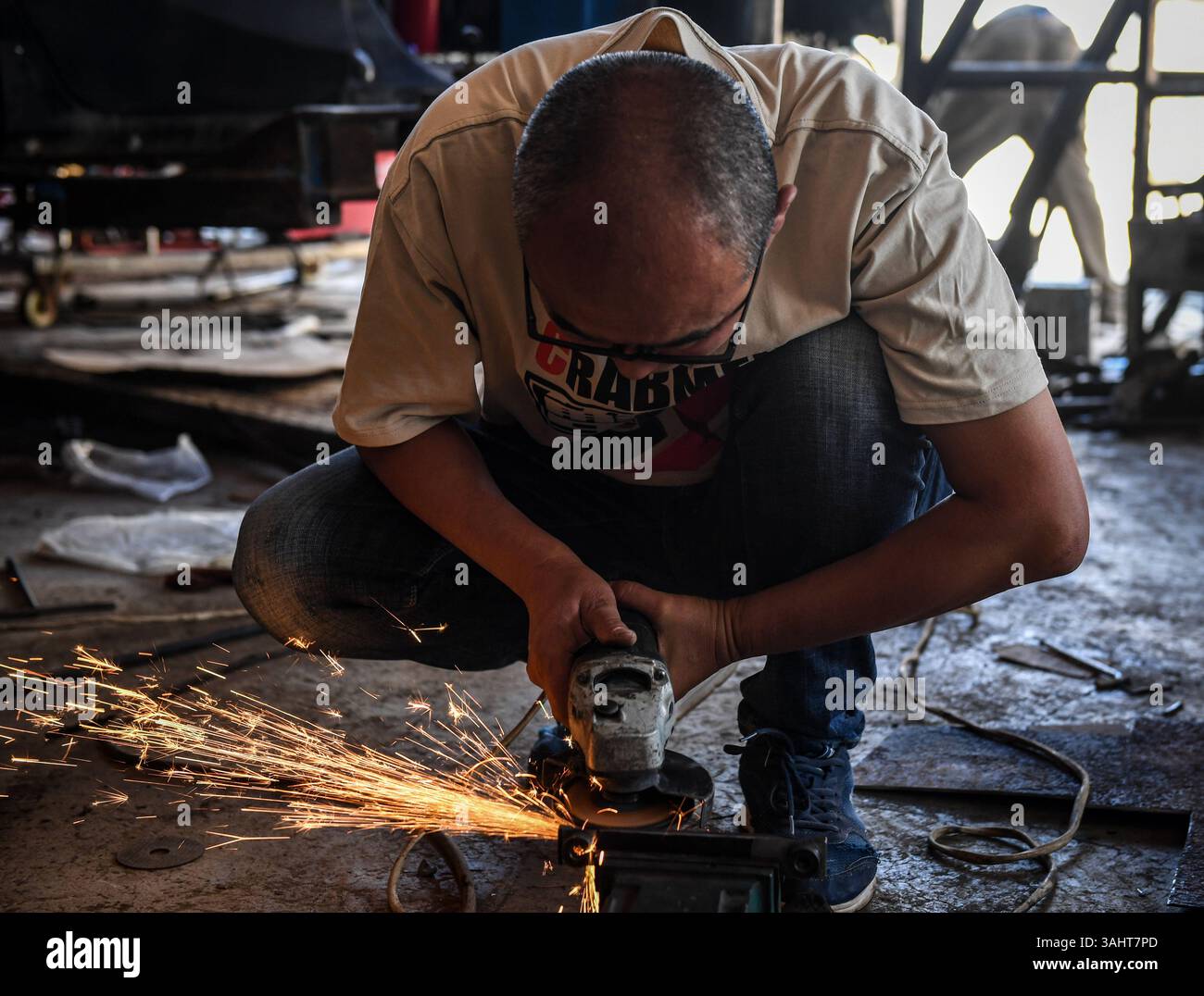 (250410) -- NAIROBI, 10 aprile 2025 (Xinhua) -- Lu Jin taglia parti di veicoli in un'officina a Mogotio, Kenya, 6 marzo 2025. PER ANDARE AVANTI CON "Feature: Il pilota cinese va tutto alla grande al Kenya Safari Rally" (Xinhua/li Yahui) Foto Stock