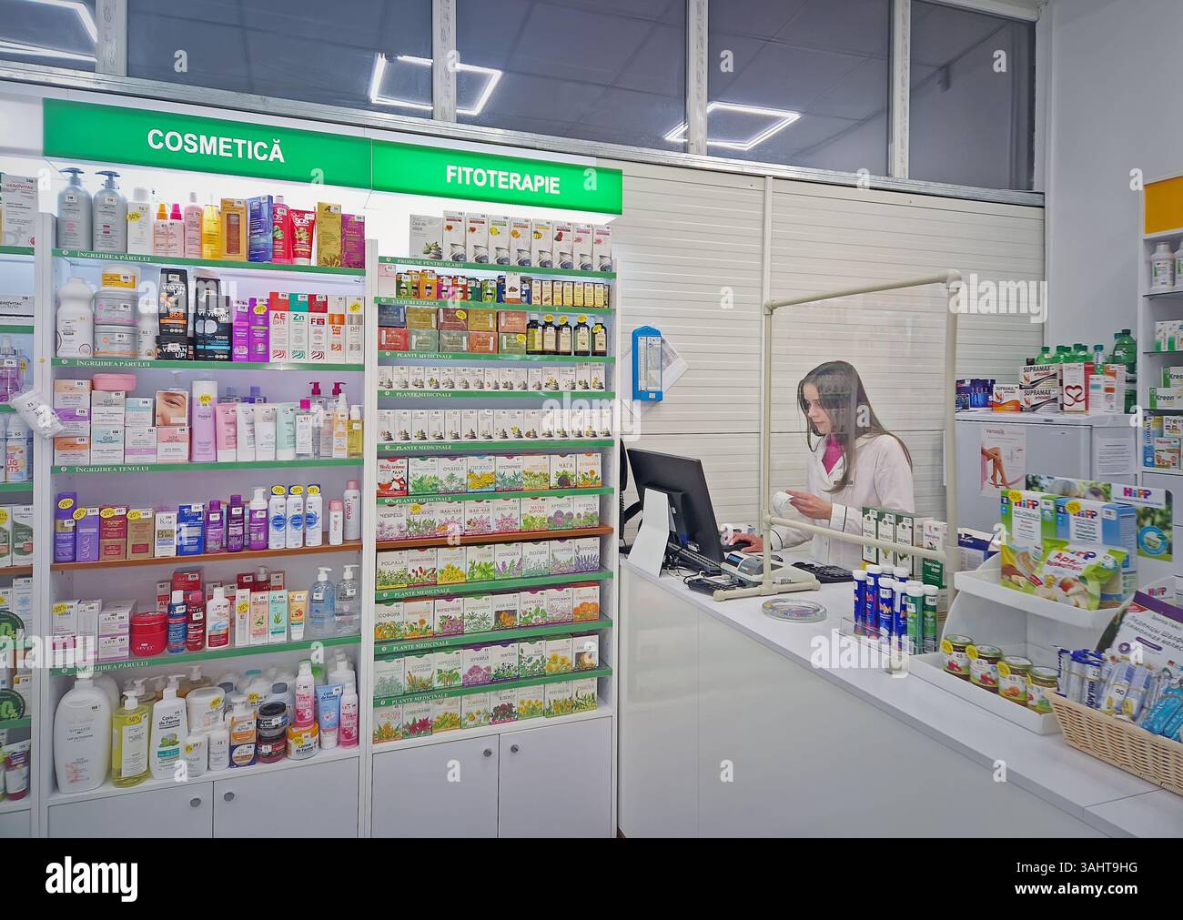 UNGHENI, MOLDAVIA - 17 DICEMBRE 2023 Visualizza all'interno della farmacia con farmacista sul posto di lavoro che legge prescrizione medica. Sanità e cosmetici - Immagine stock catturata con smartphone
