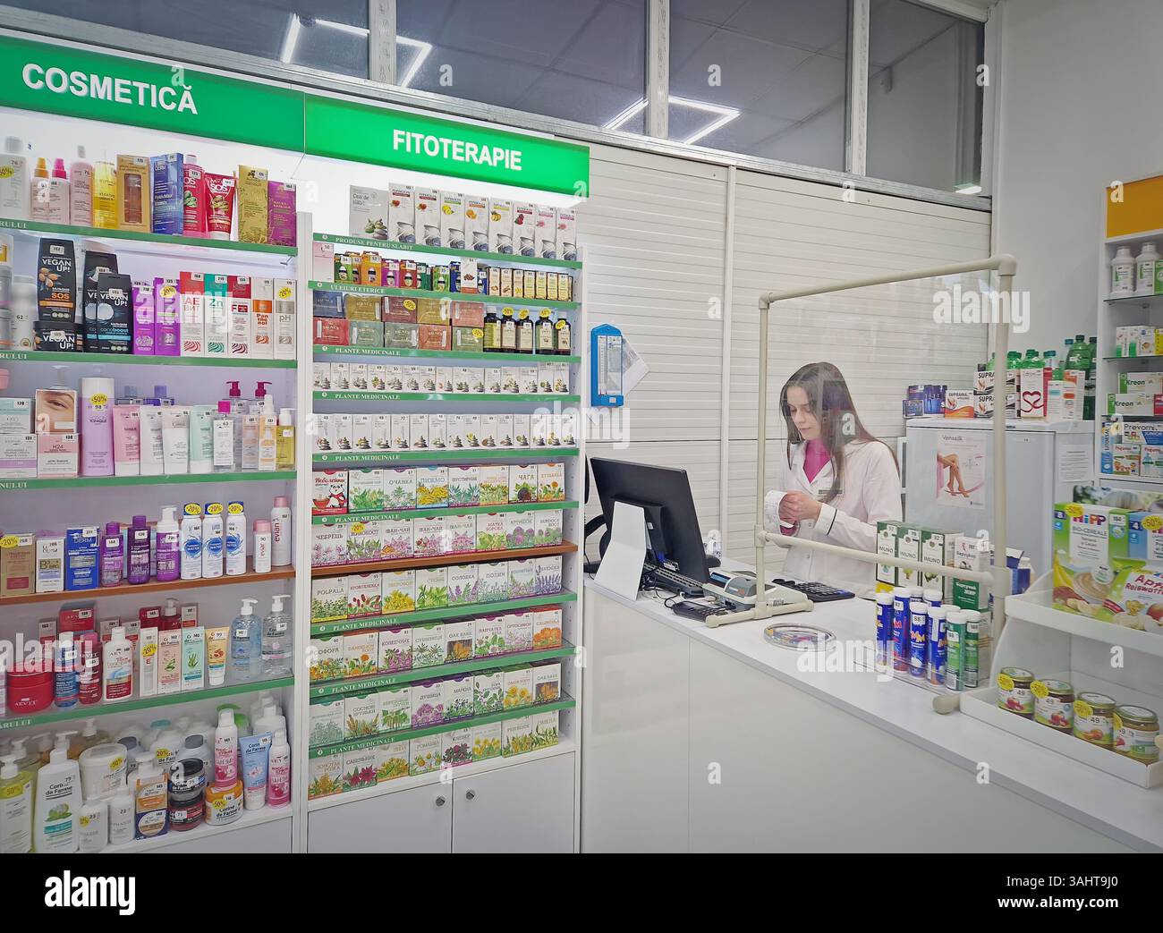 UNGHENI, MOLDAVIA - 17 DICEMBRE 2023 Visualizza all'interno della farmacia con farmacista sul posto di lavoro che legge prescrizione medica. Sanità e cosmetici - Immagine stock catturata con smartphone