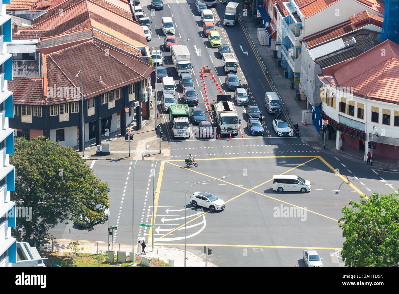 Vista dall'alto ravvicinata dello stato dell'incrocio stradale. Un camion in mezzo alla strada che lavora, i veicoli viaggiano, la rete di città intelligenti di Singapore. Foto Stock