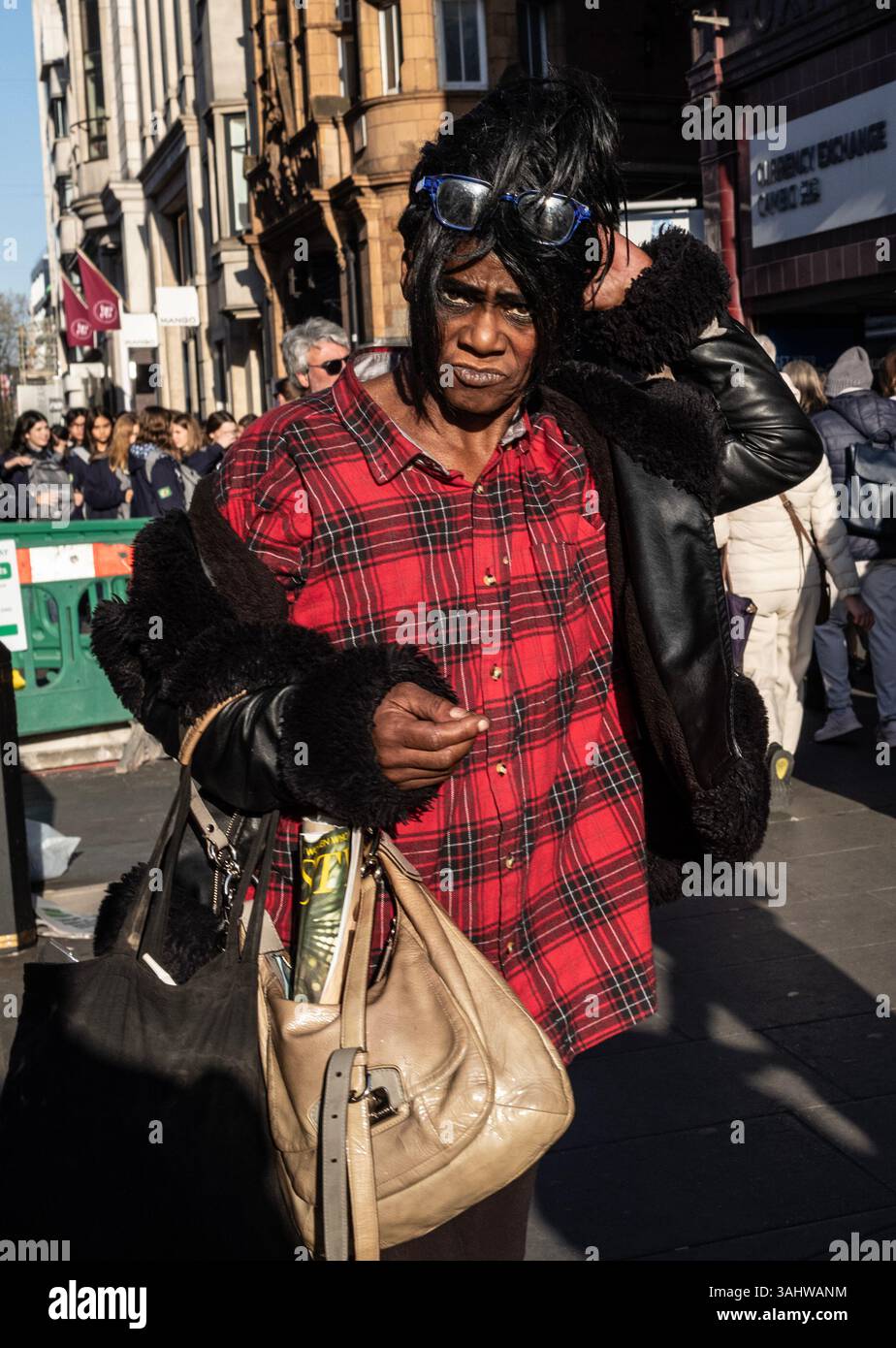 I pedoni si dirigono lungo Oxford Street alla fine di una giornata lavorativa, mentre il semaforo scende verso il crepuscolo, Londra, Inghilterra, Regno Unito Foto Stock