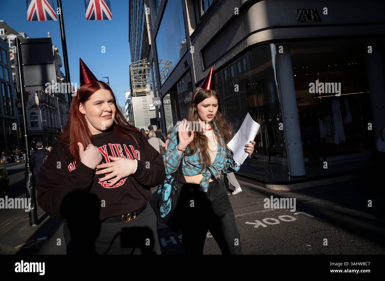 I pedoni si dirigono lungo Oxford Street alla fine di una giornata lavorativa, mentre il semaforo scende verso il crepuscolo, Londra, Inghilterra, Regno Unito Foto Stock