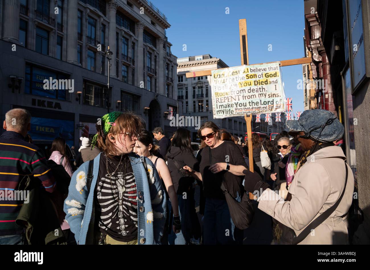 I pedoni si dirigono lungo Oxford Street alla fine di una giornata lavorativa, mentre il semaforo scende verso il crepuscolo, Londra, Inghilterra, Regno Unito Foto Stock