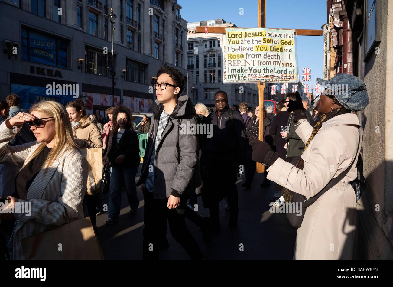 I pedoni si dirigono lungo Oxford Street alla fine di una giornata lavorativa, mentre il semaforo scende verso il crepuscolo, Londra, Inghilterra, Regno Unito Foto Stock