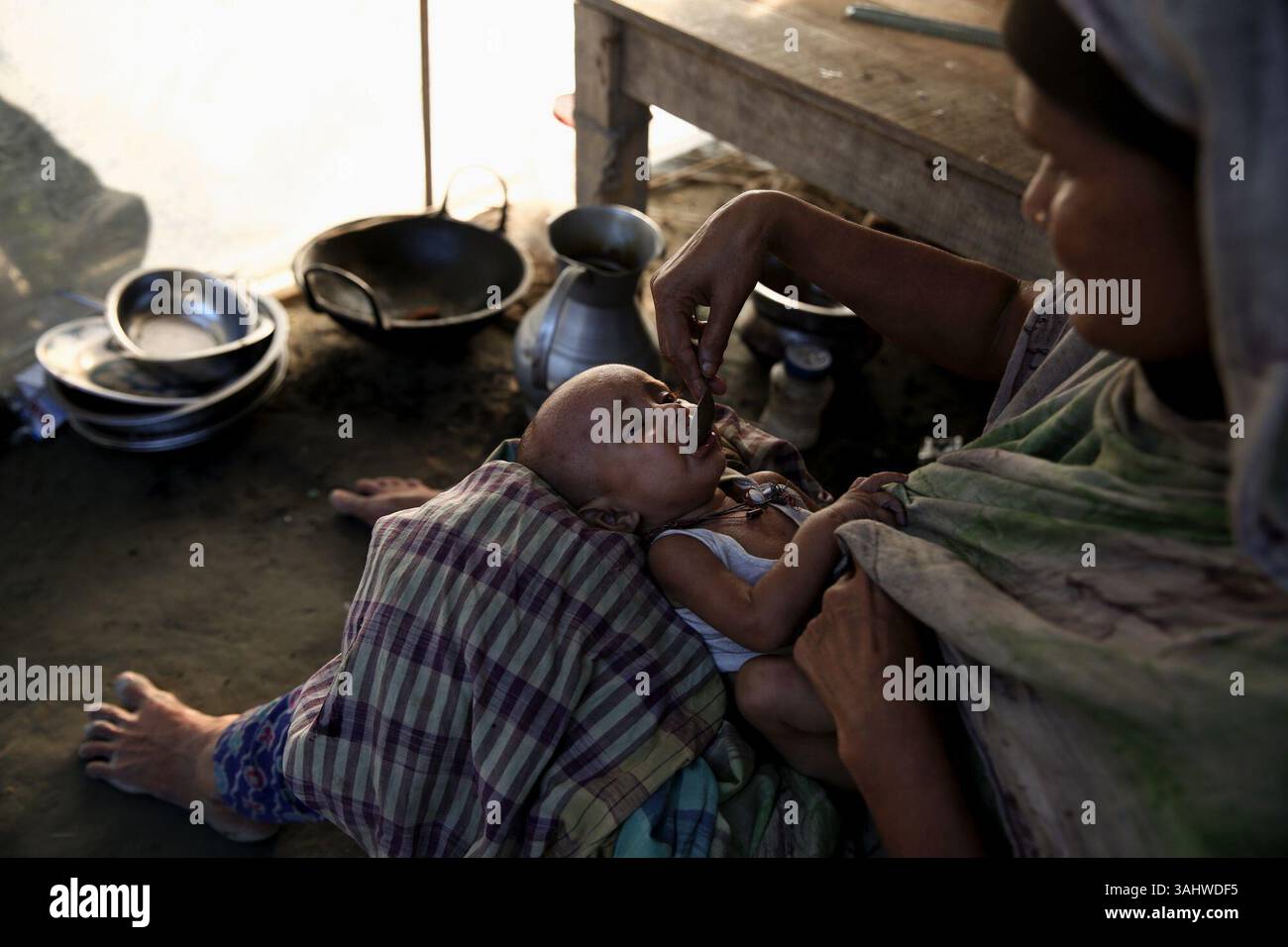 19 agosto 2017 - Dacca, Bangladesh - Una madre dà da mangiare a suo figlio in un campo improvvisato a Guthail, jamalpur, bangladesh. In queste zone colpite dalle inondazioni si richiedono acqua potabile pura e medicine. (Immagine di credito: © Mushfiqul Alam via ZUMA Wire) Foto Stock