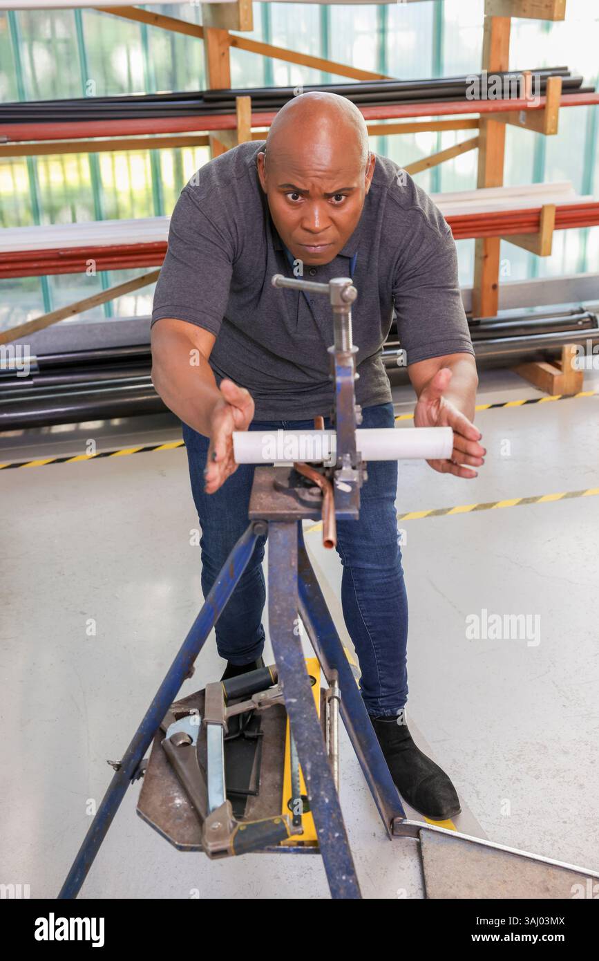 Uomo disabile che lavora in officina Foto Stock