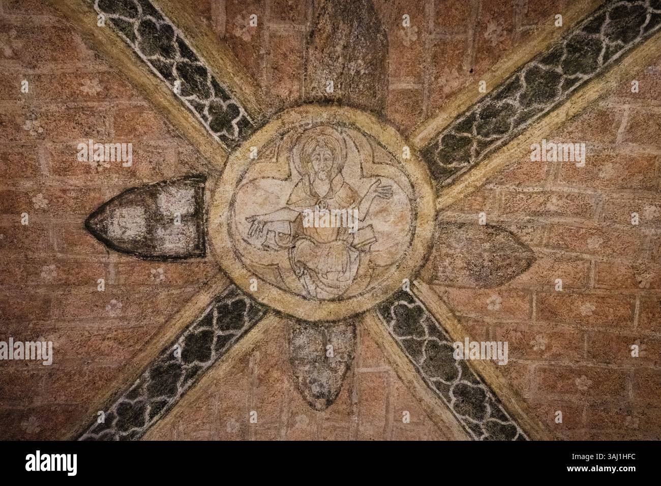 sacro dipinto medievale di Gesù Cristo in cerchio con croci, sul soffitto della cripta sotterranea della chiesa Foto Stock