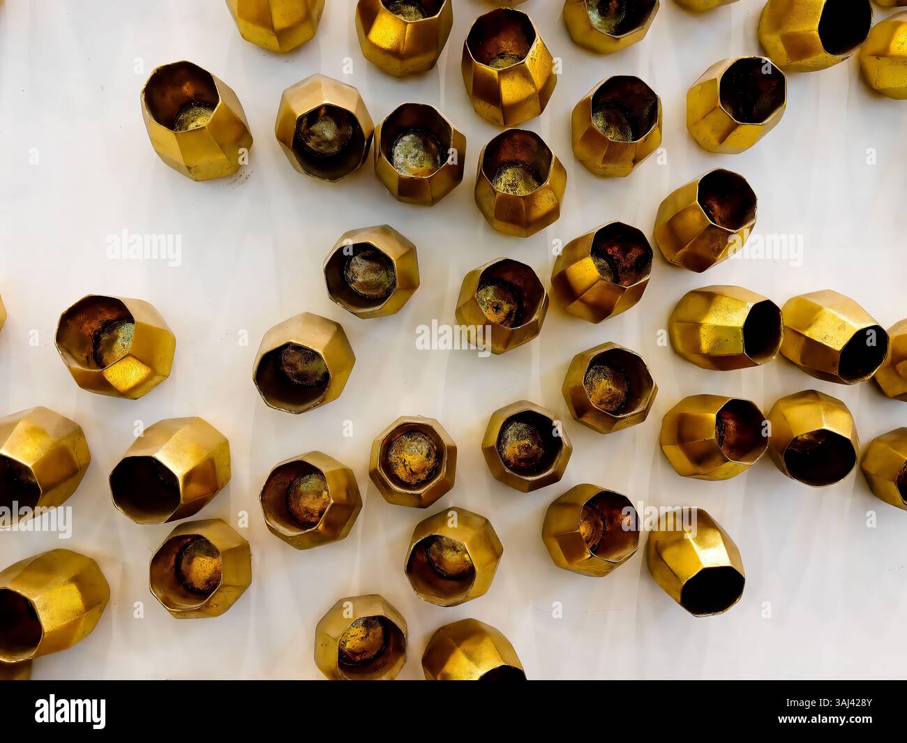 Le tazze geometriche dorate disposte a parete formano una texture moderna e scultorea, ideale per i temi di arredamento di lusso e i concetti artistici contemporanei. Foto Stock