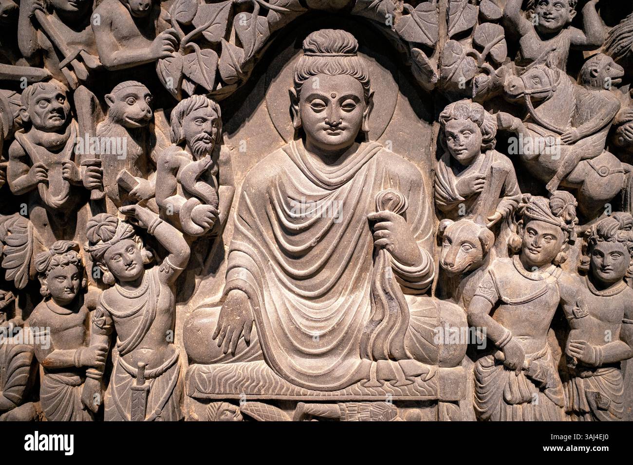 WASHINGTON DC - Un pannello di bassorilievo scisto dell'antica Gandhara (moderno Pakistan/Afghanistan) che raffigura l'Illuminismo del Buddha, esposto allo Smithsonian National Museum of Asian Art Creato durante la dinastia Kushan (fine II-inizio III secolo d.C.), questo pannello faceva parte di una serie di quattro scene che adornavano uno stupa buddista. La scultura mostra il sereno Buddha in meditazione con la mano nel gesto toccante della terra (bhumisparsha mudra), circondato dall'esercito di demoni distorto di Mara che tenta di distrarlo dal raggiungere l'illuminazione. Foto Stock
