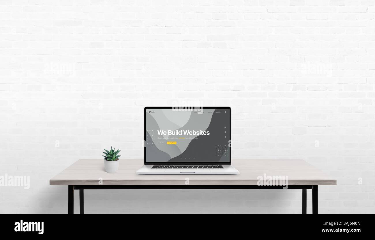 Scrivania semplice con laptop e impianto, design Web concettuale visualizzato sullo schermo, parete bianca in mattoni sullo sfondo con spazio vuoto per poliziotti promozionali Foto Stock