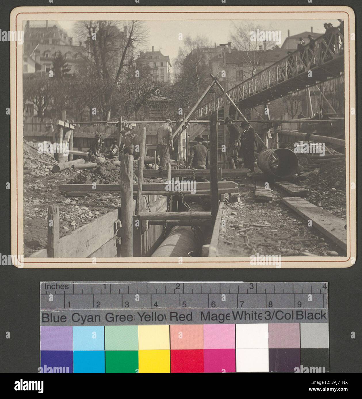 L'immagine mostra i lavoratori che posano tubi nel fiume Limmat vicino a Platzspitz a Zürich, una scena che cattura l'attività industriale in un ambiente naturale, riflettendo lo sviluppo urbano dell'inizio del XX secolo. Foto Stock