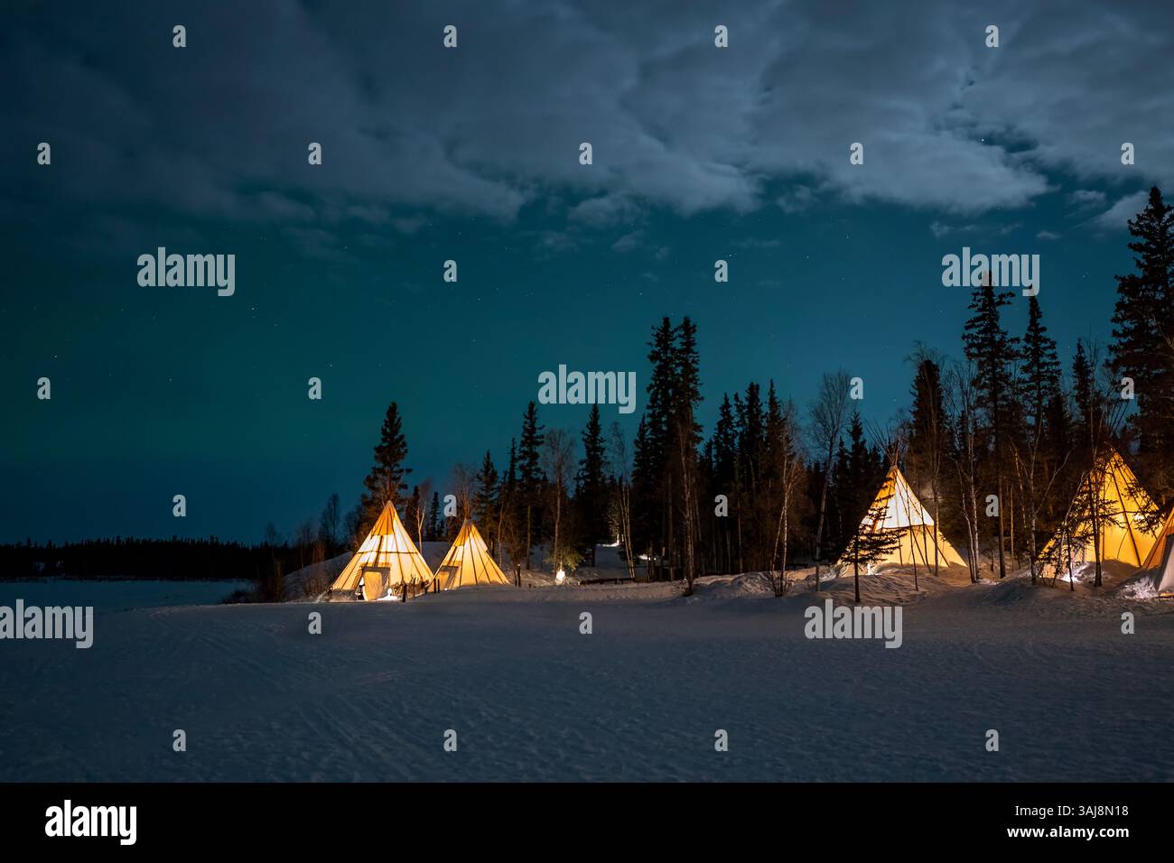 Teepee illuminate nelle foreste vicino a Yellowknife, territori del Nord-Ovest, Canada Foto Stock
