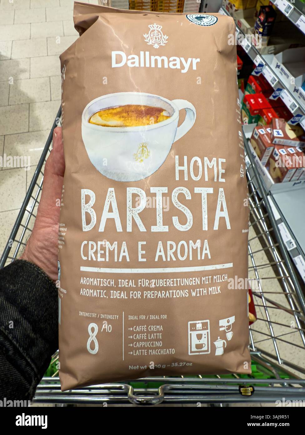 Il cliente ha in mano una busta da un chilogrammo di caffè da barista domestico nel carrello della spesa - FRANCOFORTE, GERMANIA - 9 APRILE 2025 Foto Stock