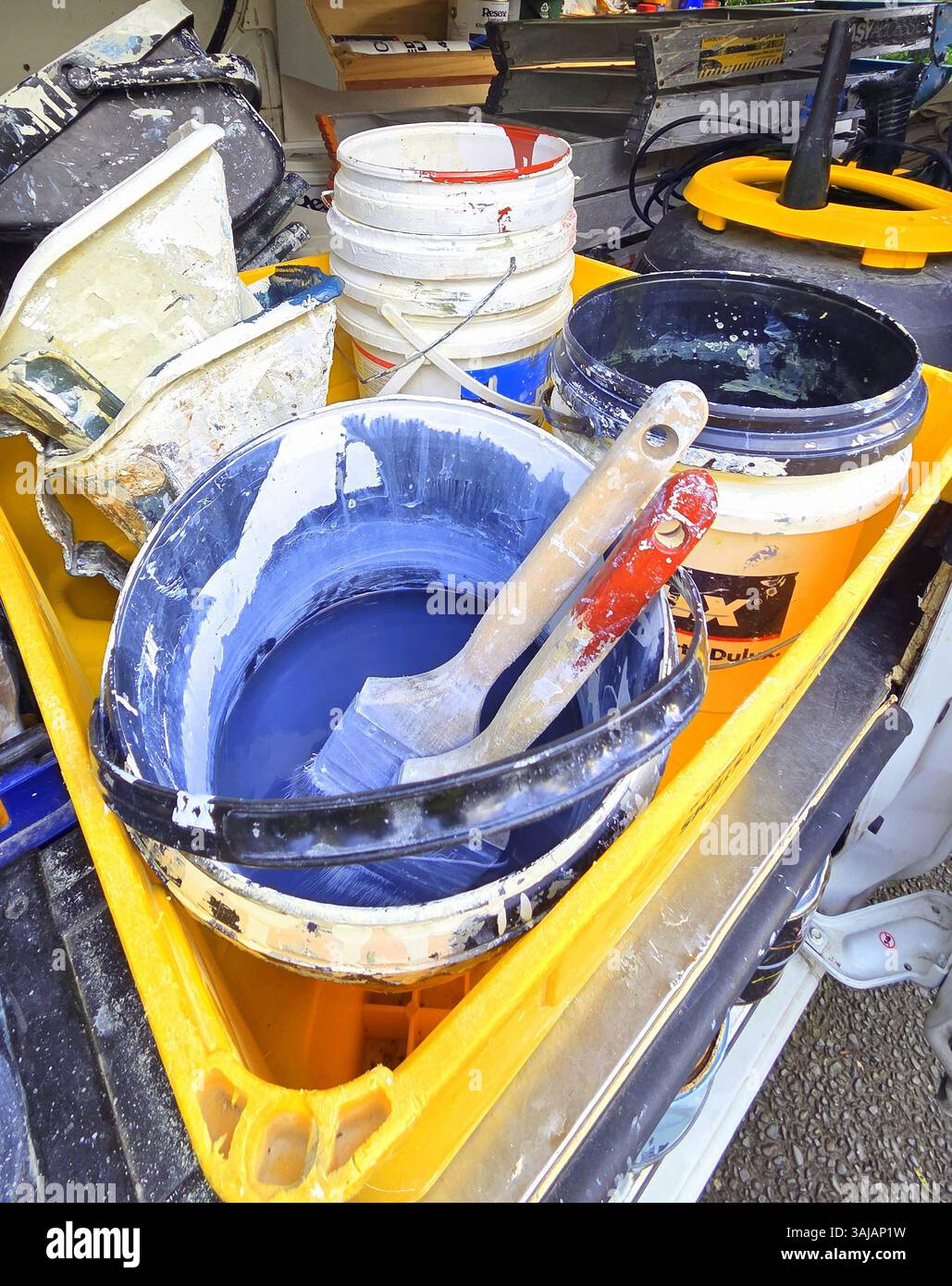 Pennelli per pittori e attrezzature per secchio in plastica in una cassa all'interno di un furgone Foto Stock