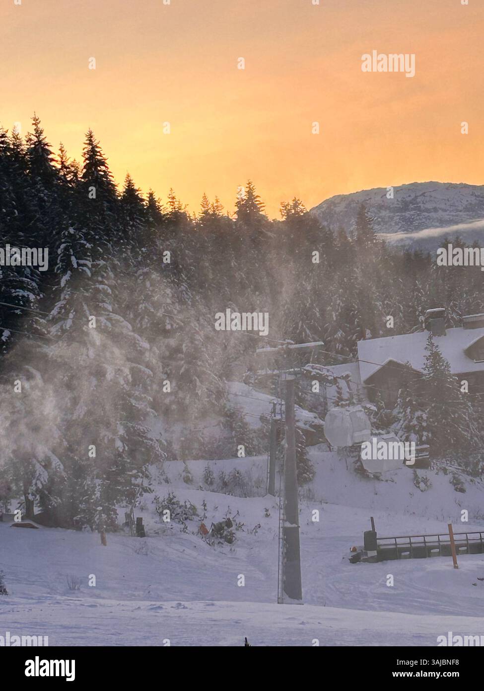 Stazione di gondola coperta di neve al tramonto nella foresta di montagna - Immagine stock catturata con smartphone