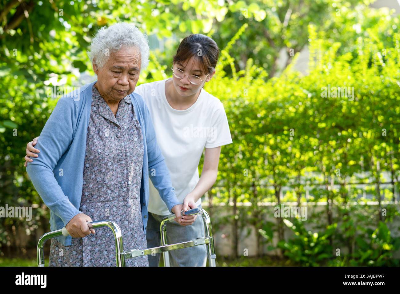 Assistenza e cura anziani asiatici o anziana donna uso escursionista con forte salute, mentre camminando al parco in felice vacanza fresca. Foto Stock