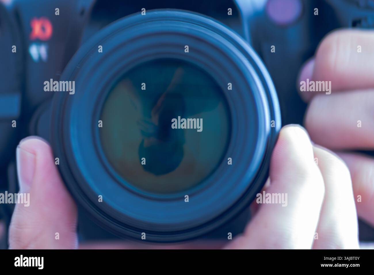 Autoritratto inverso di un uomo riflesso nell'obiettivo della fotocamera Foto Stock