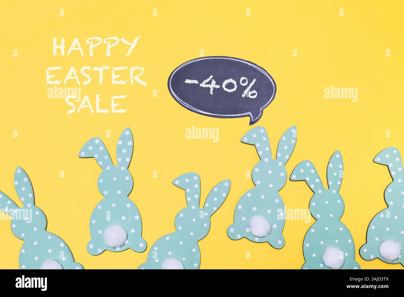 Lavagna con disegno di coniglio e le parole Happy Easter sale scritte sopra. I conigli sono disposti in fila e hanno tutte dimensioni diverse Foto Stock
