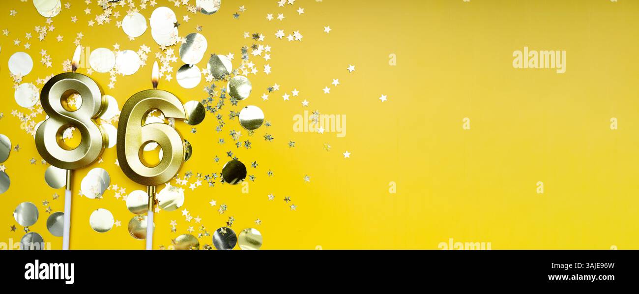 Ottantasei anni di compleanno. Numero 86 candela d'oro per festeggiare. Sfondo festivo giallo. Concetto di festeggiare il compleanno o l'anniversario. Banner. Foto Stock