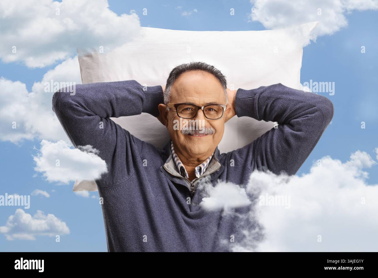 Uomo maturo che riposa su un cuscino tra nuvole nel cielo Foto Stock