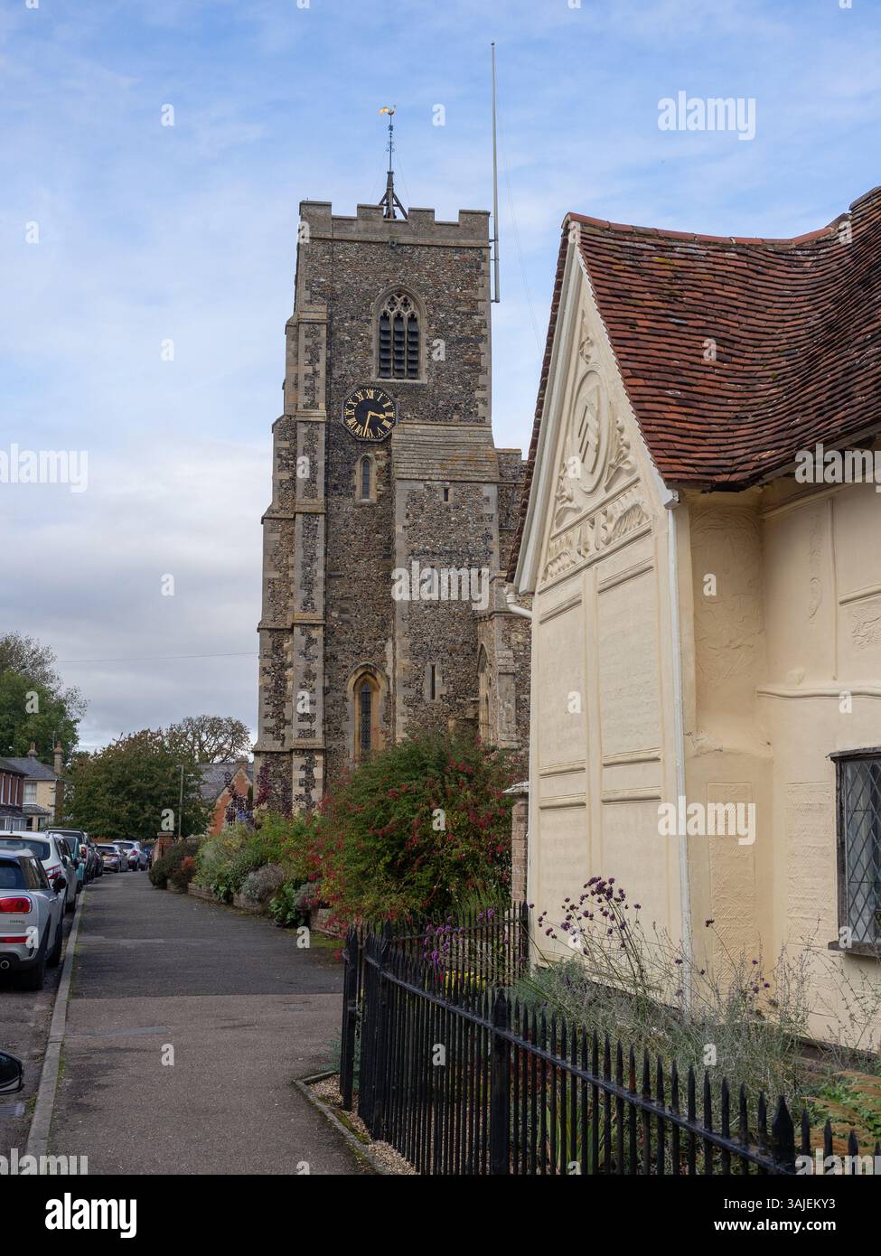 Scena di strada, Clare, Suffolk, Regno Unito; Antica Casa Museo in primo piano, chiesa di San Pietro e San Paolo sul retro. Foto Stock